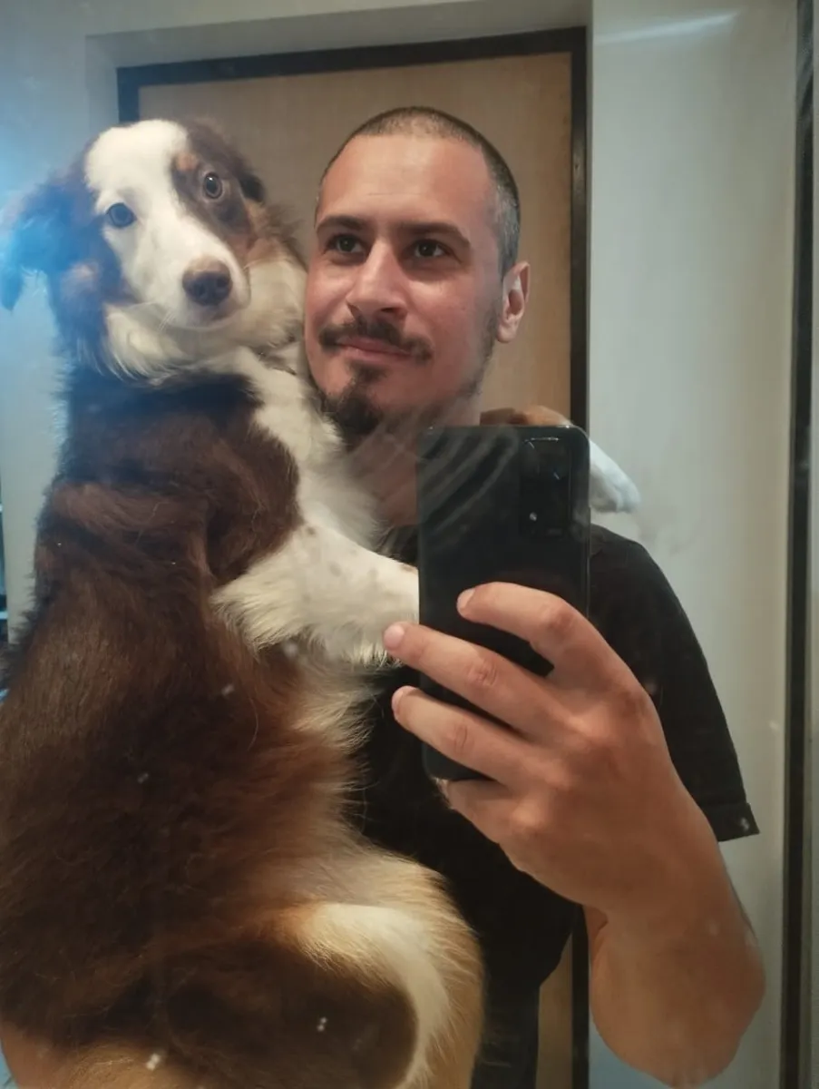 Maiko, adestrador de cães da MY DOG, no colo com um border collie filhote